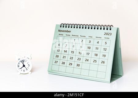 Kalender vom November 2023 und kleine Uhr auf weißem Hintergrund isoliert Stockfoto