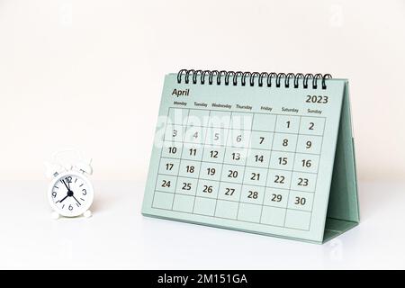 April 2023 Kalender und kleine Uhr auf weißem Hintergrund isoliert Stockfoto