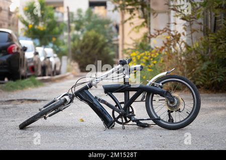 Ein Fahrrad mit einem in zwei Hälften zerbrochenen Rahmen steht auf der Straße Stockfoto