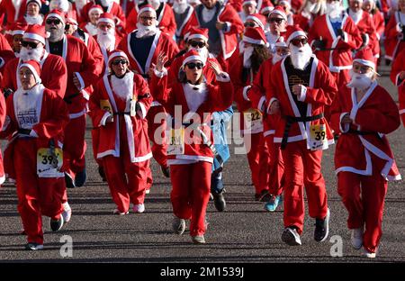 Brighton, Großbritannien. 10.. Dezember 2022. Die Teilnehmer kleiden sich wie der Weihnachtsmann und nehmen an der alljährlichen Santa Dash entlang der Küste von Hove Teil, um die Rockinghorse Children's Charity zu unterstützen, die kranke und behinderte Kinder in ganz Sussex unterstützt. Kredit: James Boardman/Alamy Live News Stockfoto