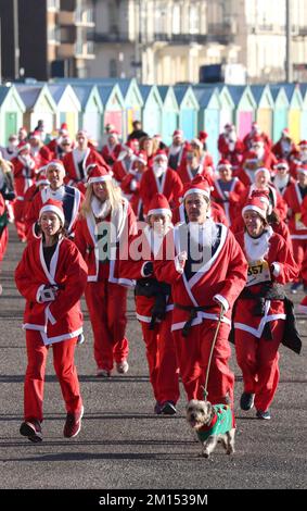 Brighton, Großbritannien. 10.. Dezember 2022. Die Teilnehmer kleiden sich wie der Weihnachtsmann und nehmen an der alljährlichen Santa Dash entlang der Küste von Hove Teil, um die Rockinghorse Children's Charity zu unterstützen, die kranke und behinderte Kinder in ganz Sussex unterstützt. Kredit: James Boardman/Alamy Live News Stockfoto