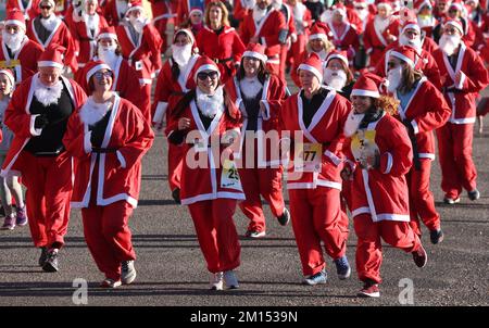 Brighton, Großbritannien. 10.. Dezember 2022. Die Teilnehmer kleiden sich wie der Weihnachtsmann und nehmen an der alljährlichen Santa Dash entlang der Küste von Hove Teil, um die Rockinghorse Children's Charity zu unterstützen, die kranke und behinderte Kinder in ganz Sussex unterstützt. Kredit: James Boardman/Alamy Live News Stockfoto