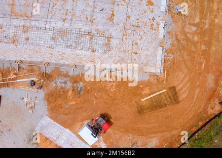 Auf der Baustelle werden Bewehrungsstahlstäbe auf Betonfundamenten installiert, um ihre Festigkeit zu verstärken Stockfoto