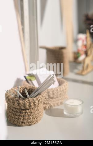 Kleiner Jutekorb zum Aufbewahren der Haken. Handgefertigte Inneneinrichtung und Accessoires. Natürliches Strickseil. Stockfoto