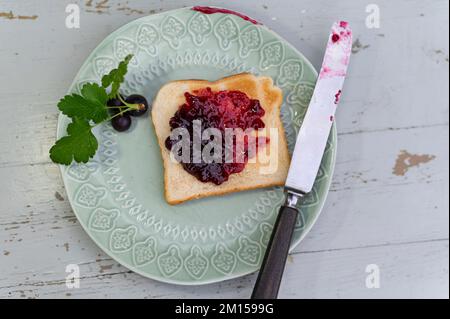 Getoastetes Brot mit schwarzer Johannisbeermarmelade Stockfoto