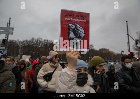 Berlin, Deutschland. 10.. Dezember 2022. Viele Demonstranten versammelten sich am 10. Dezember 2022 in Berlin zu Protesten gegen das iranische Regime. Die Demonstranten hielten zahlreiche Schilder, die den Tod der Mullahs, die Freiheit des Lebens der Frau und die Hinrichtungen im Iran zeigten. Die Proteste kommen inmitten wachsender internationaler Besorgnis über die Lage im Iran. Demonstranten riefen auch Slogans an, die den Sturz der Regierung forderten. Darüber hinaus zirkuliert nach der Hinrichtung des iranischen Rappers Mohsen Shekari eine Liste mit 24 weiteren Namen von Demonstranten, die auf ein Todesurteil warten. Auf internationaler Ebene ist das Regime stark eingeschränkt Stockfoto