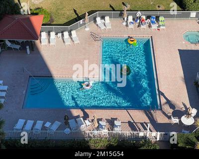 Hutchinson Island, FL, USA - 12. März 2019: Pool- und Strandszene in einer Ferienwohnung, wo Schneevögel sich entspannen und die Sonne in der w Stockfoto