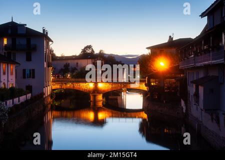 Blick auf den Sonnenuntergang über die Hauptbrücke über den Fluss Nive auf dem Weg durch das Dorf Saint Jean Pied de Port, der berühmte Ort am Weg von St. James Stockfoto