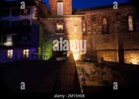 Nachtsicht auf die Kirche Notre Dame von Assomption von Saint Jean Pied de Port vom Torturm aus von der Pilgerbrücke des Stadttors. Wird Gestartet Stockfoto