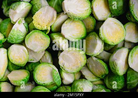 Nahaufnahme roh getrimmter und halbierter Rosenkohl: Nahaufnahme ungekochter Rosenkohl, der halbiert wurde Stockfoto