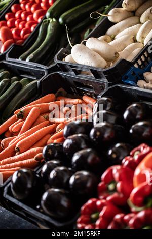 Von oben reife rote Paprika Gurken Karotten Zucchini Daikon und Pilze, die auf dem lokalen Markt stehen Stockfoto