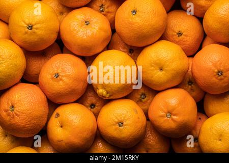 Vollbild von oben mit frischen, reifen Zitrusmandarinen, die als Hintergrund zusammengestellt wurden Stockfoto