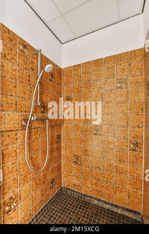 An den gefliesten Wänden im Waschraum zu Hause angebrachte Duschzapfhähne Stockfoto