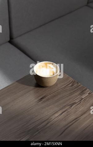 Von oben sehen Sie frischen aromatischen Cappuccino in Keramikbechern, die in einer Ecke des Holztischs im modernen Café platziert werden Stockfoto