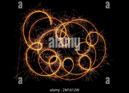 Kreise mit Funken auf schwarzem Hintergrund. Festliche Glitzer, abstrakte Silvesterlichter Stockfoto