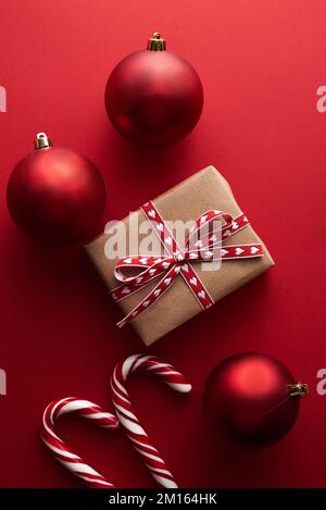 Top View Kunsthandwerkpapier geschenkbox mit roter Schleife auf rotem Hintergrund mit Kopierraum Stockfoto