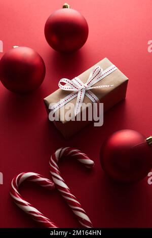 Top View Kunsthandwerkpapier geschenkbox mit roter Schleife auf rotem Hintergrund mit Kopierraum Stockfoto