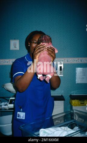 Kreißsaal im Krankenhaus mit Hebamme in der Hand von New Born Baby England Stockfoto