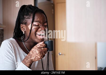 Glückliche schwarze Frau mit einer Tasse Kaffee Stockfoto