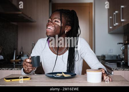 Fröhliche schwarze Frau mit einer Tasse Kaffee Stockfoto