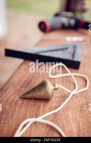 Nahaufnahme eines Pendels, Bauwerkzeug auf dem Tisch Stockfoto