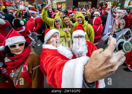 New York, USA. 10.. Dezember 2022. Feierliche, als Weihnachtsmann verkleidete Gäste haben Spaß am Times Square während der jährlichen SantaCon in New York City. Kredit: Enrique Shore/Alamy Live News Stockfoto