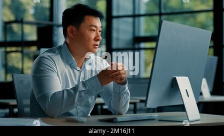 Asiatischer Geschäftsberater, Büroangestellter, der mit einer Kundenkonferenz kommuniziert, Videochat, an dem ein chinesischer Geschäftsmann arbeitet Stockfoto