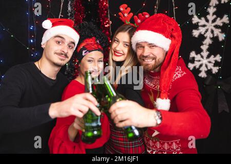 Vier Freunde feiern Silvester mit Bierflaschen. Stockfoto
