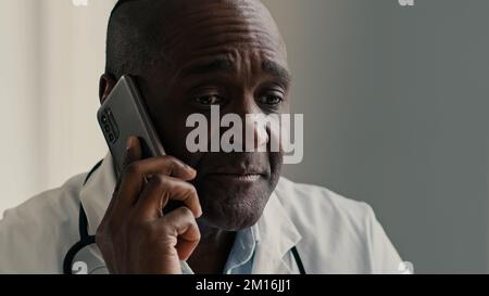 Afroamerikanischer ethnischer Arzt Mann Therapeut Mediziner konsultieren Patient mit Mobiltelefon männlicher professioneller Berater Arzt sprechen weit virtuell Stockfoto