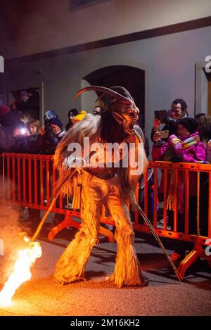 Maskierte Teufelsbiester paradieren durch das Dorf und erschrecken die Menge, während diese folklorische alpine Tradition am Leben erhalten bleibt Stockfoto