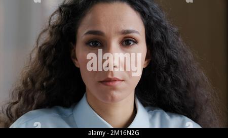 Close up ernste weibliche Gesicht schöne Frau mit natürlichen Make-up perfekte Haut arabisch junge Mädchen Studentin Geschäftsfrau mit lockigen Frisur trägt Form Stockfoto