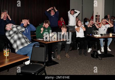 Englische Fans reagieren, nachdem Harry Kane bei einer Vorführung des Viertelfinalspiels der FIFA-Weltmeisterschaft zwischen England und Frankreich in der 76 Lounge im Lamex Stadium, Stevenage, einen Elfmeter verpasst hat. Foto: Samstag, 10. Dezember 2022. Stockfoto