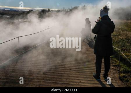 Reikiavik, Island. 21.. Okt. 2022. Man sieht Leute, die in der Nähe der Fumarolen im geothermischen Park Haukadalur Fotos machen. Die geothermische Region in der Nähe des Flusses HvitÃ und der Stadt ReykjavÃ-k beherbergt den geothermischen Park Haukadalur. Hier befindet sich Strokkur, einer der berühmtesten Geysire Islands, der im Durchschnitt alle 4 bis 8 Minuten ausbricht, mit einer durchschnittlichen Höhe von 15 bis 20 Metern, manchmal bis zu 40 Meter. Im Park gibt es mehrere geothermische Merkmale wie Schlammbecken, Fumarolen, Algenablagerungen und andere Geysire daneben und um ihn herum. (Bild: © Jorge Castellanos/SOPA Stockfoto