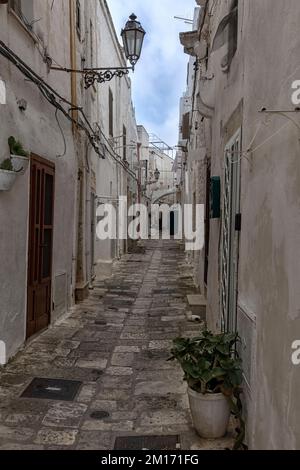 OSTUNI, ITALIEN - 18. OKTOBER 2022: Blick entlang der engen Gasse in der Altstadt Stockfoto