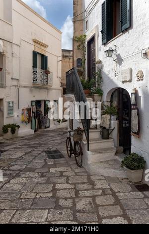 OSTUNI, ITALIEN - 18. OKTOBER 2022: Außenansicht der hübschen Galerie Bottega d'Arte in der Altstadt Stockfoto