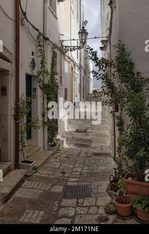 OSTUNI, ITALIEN - 18. OKTOBER 2022: Blick entlang der engen Gasse in der Altstadt Stockfoto