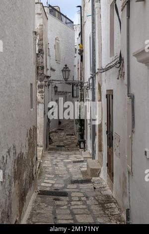 OSTUNI, ITALIEN - 18. OKTOBER 2022: Blick entlang der engen Gasse in der Altstadt Stockfoto