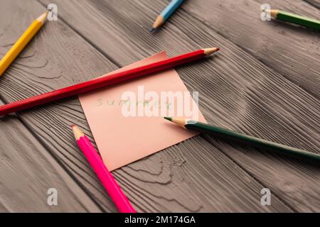 Bunte Buntstifte zeichnen Papierkartenschrift Sommer. Gelbe rote blaue Bleistifte. Sommerhintergrund Vorlage Modellraum leer bunt Stockfoto