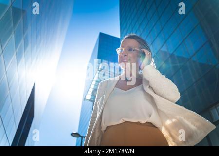 Selbstbewusste und leistungsstarke Geschäftsfrau, die mit ihrem Mobiltelefon spricht. Leitende Geschäftsfrau am Arbeitsplatz Stockfoto