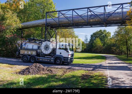 Staubsauger und Abwasserreiniger im grünen Park. Stapler speziell für Auffangbecken-Reiniger. Stockfoto