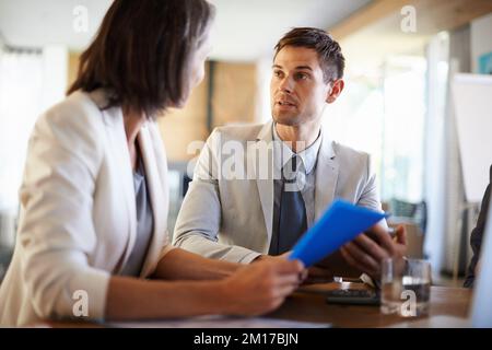 Sie haben heute viel auf ihrem Teller. Zwei Geschäftsleute, die bei einem Treffen eine wichtige Diskussion führen. Stockfoto