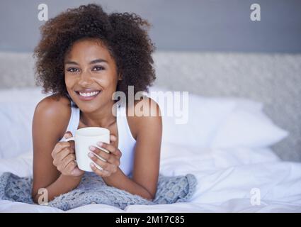 Bereit für ein lustiges Wochenende. Porträt einer jungen Frau, die eine Tasse Kaffee genießt. Stockfoto