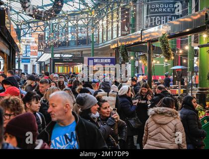 London, Großbritannien. 08.. Dezember 2022. Festliche Einkäufer, Besucher und Touristen drängen sich in die Markthallen des Borough Market, um Kunsthandwerk zu kaufen und einen Glühwein und andere saisonale Angebote zu genießen. Kredit: Imageplotter/Alamy Live News Stockfoto