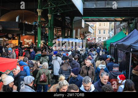 London, Großbritannien. 08.. Dezember 2022. Festliche Einkäufer, Besucher und Touristen drängen sich in die Markthallen des Borough Market, um Kunsthandwerk zu kaufen und einen Glühwein und andere saisonale Angebote zu genießen. Kredit: Imageplotter/Alamy Live News Stockfoto