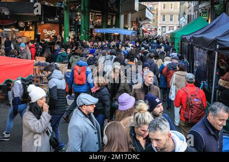 London, Großbritannien. 08.. Dezember 2022. Festliche Einkäufer, Besucher und Touristen drängen sich in die Markthallen des Borough Market, um Kunsthandwerk zu kaufen und einen Glühwein und andere saisonale Angebote zu genießen. Kredit: Imageplotter/Alamy Live News Stockfoto