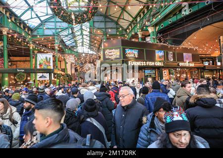 London, Großbritannien. 08.. Dezember 2022. Festliche Einkäufer, Besucher und Touristen drängen sich in die Markthallen des Borough Market, um Kunsthandwerk zu kaufen und einen Glühwein und andere saisonale Angebote zu genießen. Kredit: Imageplotter/Alamy Live News Stockfoto