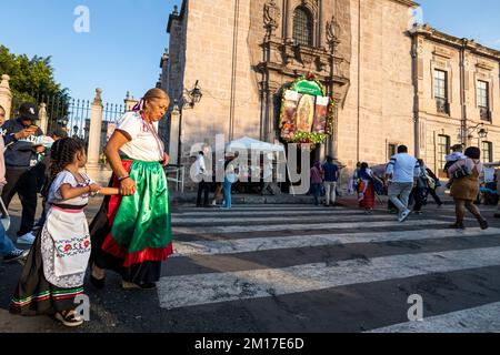 Morelia, Mexiko, 10. Dezember 2022, kommen Eine Großmutter und ihre Enkelin während der Feierlichkeiten zum Tag der Jungfrau von Guadalupe am Tempel an. Millionen Mexikaner jeden Alters feiern diesen religiösen Feiertag, der am 12.. Dezember gipfelt, indem sie sich als Juan Diego oder die Jungfrau von Guadalupe verkleiden und zu dem Tempel gehen, der der Jungfrau in jeder Stadt gewidmet ist. Brian Cocast/Alamy Live News. Stockfoto