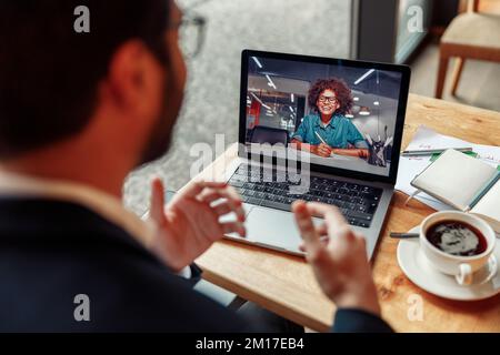 Ein Geschäftsmann hat ein Geschäftstreffen per Videoanruf im Café Stockfoto