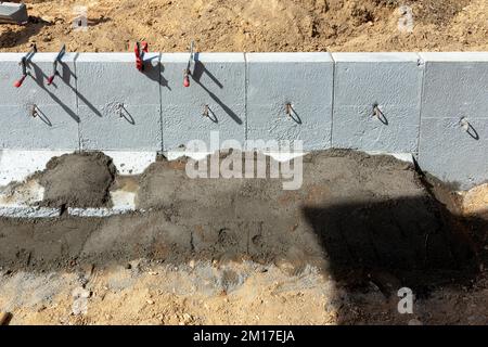 Detaildarstellung der auf einer Betondecke befestigten Bordsteine im Detail auf der Baustelle Stockfoto