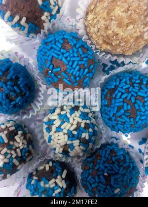 Schokoladen-Brigadeiros bedeckt mit blauen und weißen Sprenkeln Stockfoto